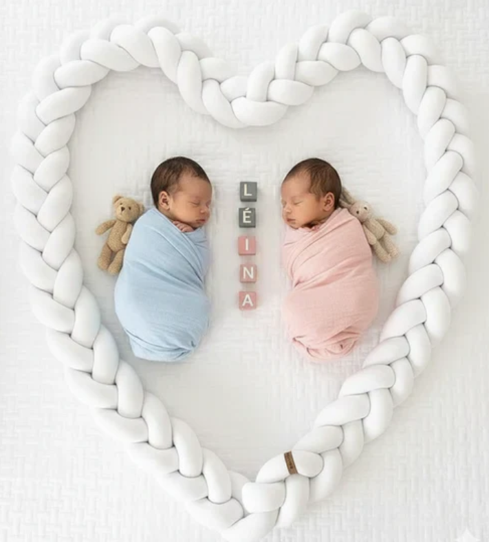 Jumeaux nouveau-nĂ©s emmaillotĂ©s dans un coussin tressĂ© en forme de cĆur