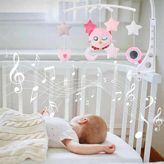 Bébé allongé regardant mobile musical rose avec chouette et étoiles