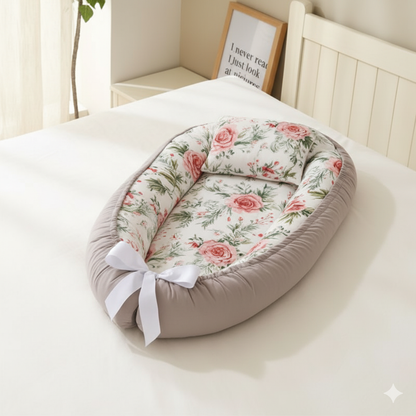 
Reducteur de lit gris avec  intérieur à motifs de roses, posé sur  lit blanc
