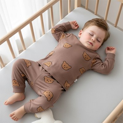 bébé dormant paisiblement en pyjama marron motif ours dans lit