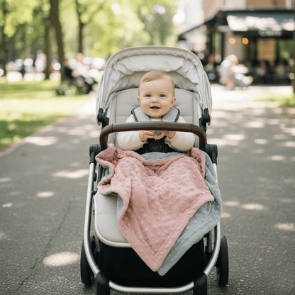 Bébé confortablement installé dans  poussette avec  couverture bébé rose à motifs en relief, parfaite pour  promenades au parc
