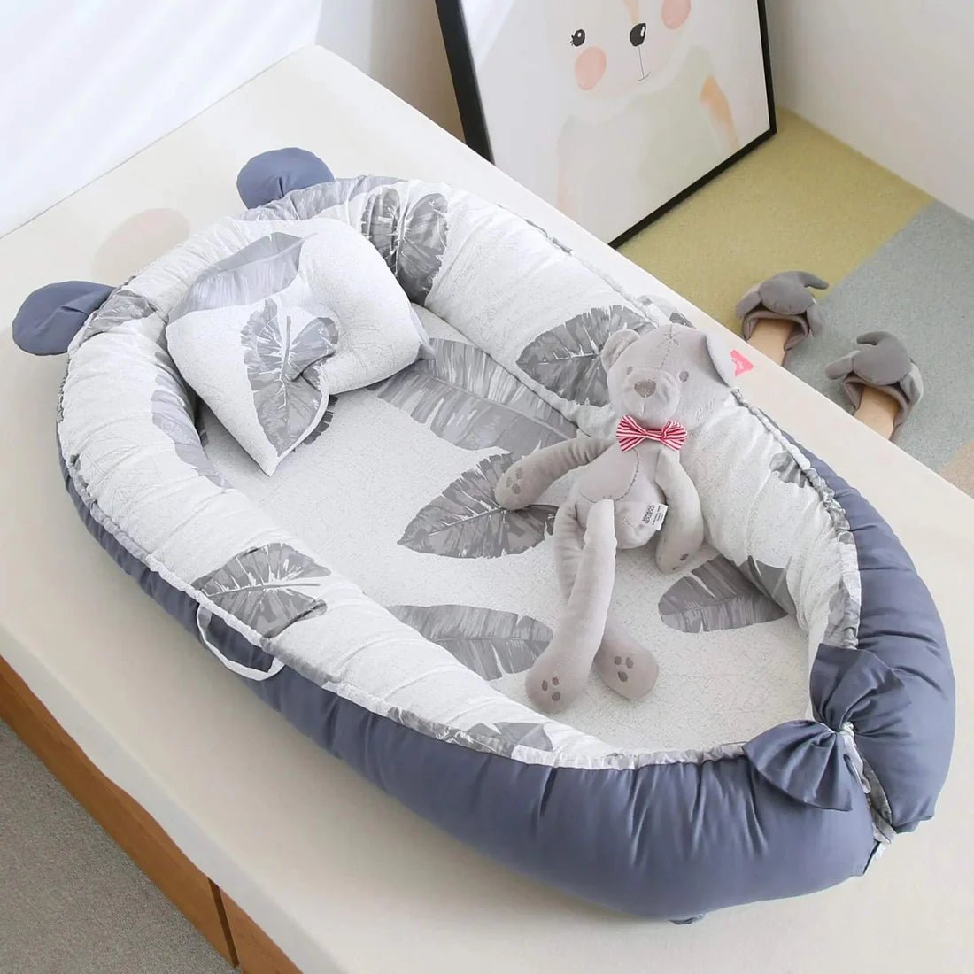 Réducteur de Lit Bébé-Cocon Motif Feuillages en Situation - Cocon bébé avec peluche éléphant dans chambre enfant colorée, démonstration d'usage quotidien et confort optimal
