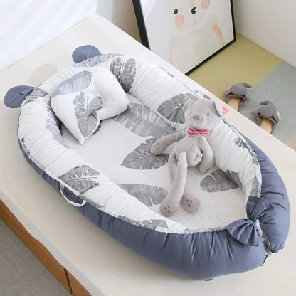 Réducteur de Lit Bébé-Cocon Motif Feuillages en Situation - Cocon bébé avec peluche éléphant dans chambre enfant colorée, démonstration d'usage quotidien et confort optimal