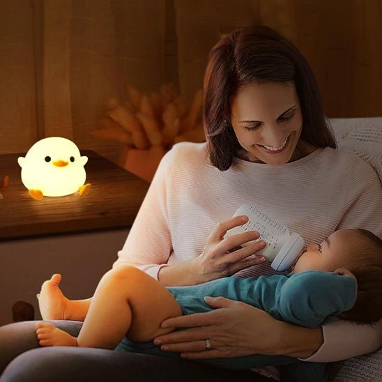 veilleuse bébé canard dans  chambre de bébé, avec  bebe  endormie dans bras de sa maman
